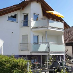 a house with a balcony with a surfboard on it at M&J FeWo in Kappel-Grafenhausen