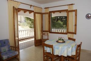 a dining room with a table and two windows at Apartamentos Jardin Playa in Punta Grossa