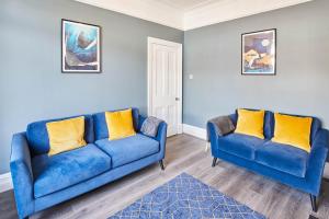 a living room with two blue couches and a rug at Host & Stay - The Old Fireman's House in Saltburn-by-the-Sea