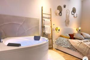 bañera en una habitación con cama en The Pearl - Jacuzzi SPA - Ecran géant - Parking, en Le Havre