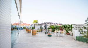 een patio met stoelen, tafels en parasols bij Hotel Xon's Valencia in Aldaya