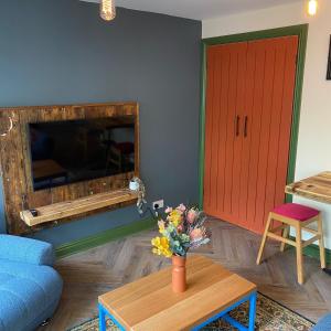 - un salon avec un canapé bleu et une porte rouge dans l'établissement The Bolthole @ Bowness - Cosy 1 Bed Apartment, à Bowness-on-Windermere