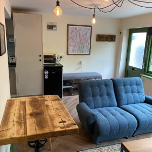 - un salon avec un canapé bleu et une table en bois dans l'établissement The Bolthole @ Bowness - Cosy 1 Bed Apartment, à Bowness-on-Windermere