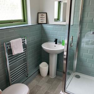 La salle de bains est pourvue d'un lavabo et d'une douche. dans l'établissement The Bolthole @ Bowness - Cosy 1 Bed Apartment, à Bowness-on-Windermere