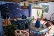 a living room with a table and a table and chairs at Casa La Palma in Chefchaouen