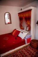 a bedroom with a red bed and a window at Casa La Palma in Chefchaouen