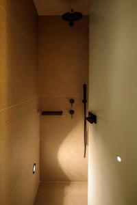 Zimmer mit Dusche und Wandlicht in der Unterkunft Agnadema Apartments in Firostefani