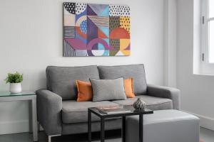 a living room with a gray couch and a table at Templeton Place by Supercity Aparthotels in London