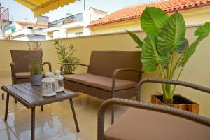 a patio with chairs and a table and plants at A perfect stay at the historical centre of Kalamata in Kalamata