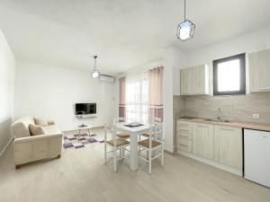 a white kitchen with a table and a couch at Rion Apartments in Ulcinj