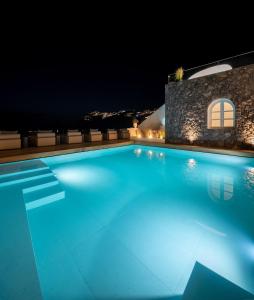 a swimming pool in a villa at night at Agnadema Apartments in Firostefani