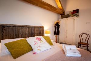1 dormitorio con 1 cama con 2 toallas en Sorelle Biologiche, en Monte Castello di Vibio