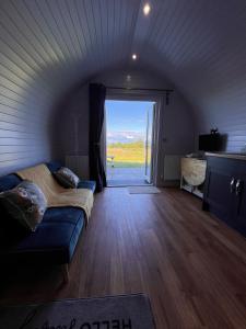 uma sala de estar com um sofá e uma porta de vidro deslizante em Honeypot Hideaways Luxury Glamping - Exclusively for Adults em Chester