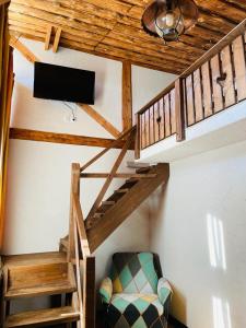 a room with stairs and a tv and a chair at Cabana Vanatorului 8 in Râşnov