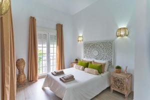 ein weißes Schlafzimmer mit einem großen Bett und grünen Kissen in der Unterkunft Villa Namaste in Adeje