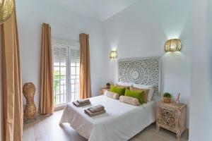 een witte slaapkamer met een groot bed met groene kussens bij Villa Namaste in Adeje