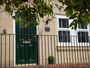 a green door on a house with a fence at 1 Wesley Mews in Alnwick