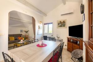 eine Küche und ein Wohnzimmer mit einem Tisch und einem TV in der Unterkunft La Maximoise in Sainte-Maxime
