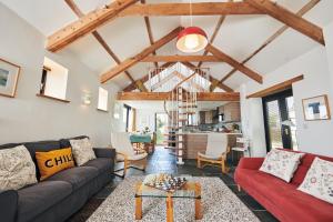 a living room with a couch and a table at The Barn and Chaffhouse-Beautifully renovated Welsh Barn in Pembrokeshire in Castlemartin