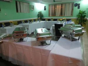 a banquet hall with tables with white table cloth at Royal Cockpit Hotels in Mpuase