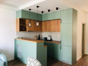 a kitchen with green cabinets and wooden counters at Apartment Sara with seaview in Budva