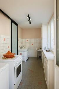 a kitchen with a white stove and a sink at L'Anjépie in Passenans