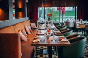 une grande salle à manger avec de longues tables et chaises dans l'établissement Van der Valk Hotel Oostzaan - Amsterdam, à Oostzaan