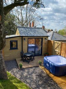um quintal com uma banheira de hidromassagem e uma cabina em Hideaway at Hestercombe em Kingston