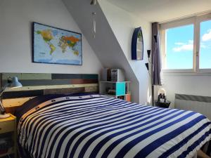 - une chambre avec un lit rayé bleu et blanc dans l'établissement Appartement Merville-Franceville-Plage, 2 pièces, 4 personnes - FR-1-465-62, à Merville-Franceville-Plage