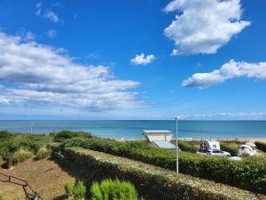 - une vue sur la plage avec une maison et une voiture dans l'établissement Appartement Merville-Franceville-Plage, 2 pièces, 4 personnes - FR-1-465-62, à Merville-Franceville-Plage