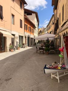 an empty street with tables and chairs and an umbrella at Zero45 San Martino Apartment in Grosseto