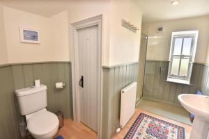 a bathroom with a toilet and a sink at Gardener's Cottage in Elgin +37 photos