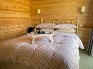 two beds in a room with wooden walls at Hideaway at Hestercombe in Kingston