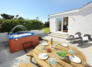 a patio with a table and a hot tub at Peninsula Cottage in Stornoway