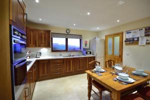 a kitchen with a wooden table and a kitchen with a tableablish at Taigh an Uillt in Valtos