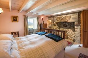 una camera da letto con un letto grande e un muro di pietra di Clashindeugle Farmhouse & Annex a Grantown on Spey