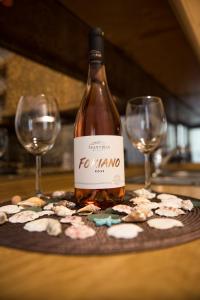 a bottle of wine and two glasses on a table at Studio Kalogridis in Kouniádhoi