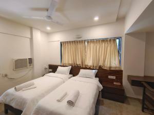 - 2 lits dans une chambre avec fenêtre dans l'établissement Astha Residency, à Mumbai