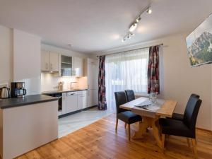 - une cuisine et une salle à manger avec une table et des chaises dans l'établissement Appartement Melodie, à Scheffau am Wilden Kaiser