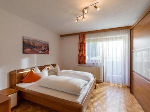 - une chambre avec un lit doté de draps blancs et d'oreillers orange dans l'établissement Appartement Melodie, à Scheffau am Wilden Kaiser
