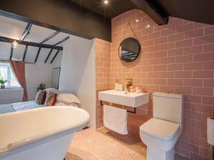 a bathroom with a tub and a toilet and a sink at Unique Romantic Getaway in Thornton