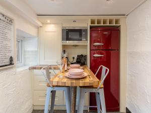 a kitchen with a table and a red refrigerator at Unique Romantic Getaway in Thornton