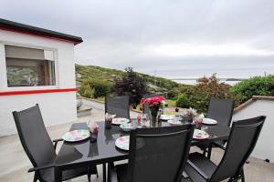 a black table with black chairs and flowers on a patio at Old Post Office in Tarbert