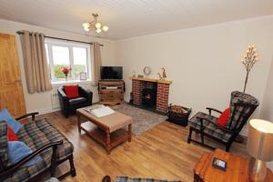 a living room filled with furniture and a fireplace at Old Post Office in Tarbert