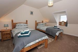 a bedroom with two beds and a window at Old Post Office in Tarbert