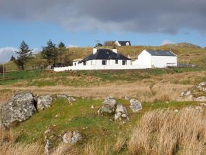 a white house on top of a grassy hill at Dunraven in Stornoway