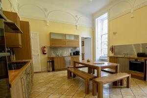 a kitchen with a table and benches in a room at Cortes House in Fraserburgh