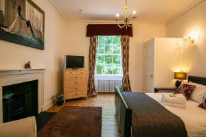 a bedroom with a bed and a fireplace and a television at Cortes House in Fraserburgh