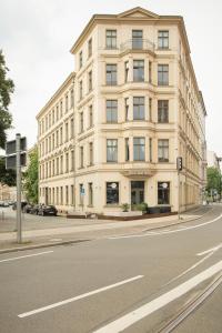 un gran edificio blanco al lado de una calle en Kokon Apartments en Leipzig