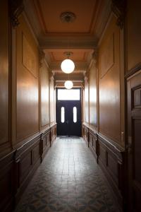 un corridoio vuoto con una porta nera e una finestra di Kokon Apartments a Lipsia